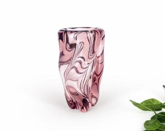 Può includere: Un vaso in vetro soffiato a mano caratterizzato da un motivo a vortice marmorizzato rosa e bianco traslucido. Il vaso presenta una forma organica irregolare con un'apertura ampia e una base curva verso l'interno, creando un aspetto fluido.