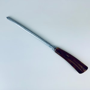May include: A silver steel knife sharpener with a brown and black striped plastic handle.