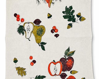 May include: A rectangular off-white kitchen towel featuring a printed pattern of autumn harvest elements including a large maple leaf, pears, apples, a pumpkin, corn, acorns, berries, and various leaves in shades of red, green, brown, and orange.