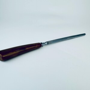 May include: A brown wooden handled steel knife sharpener.