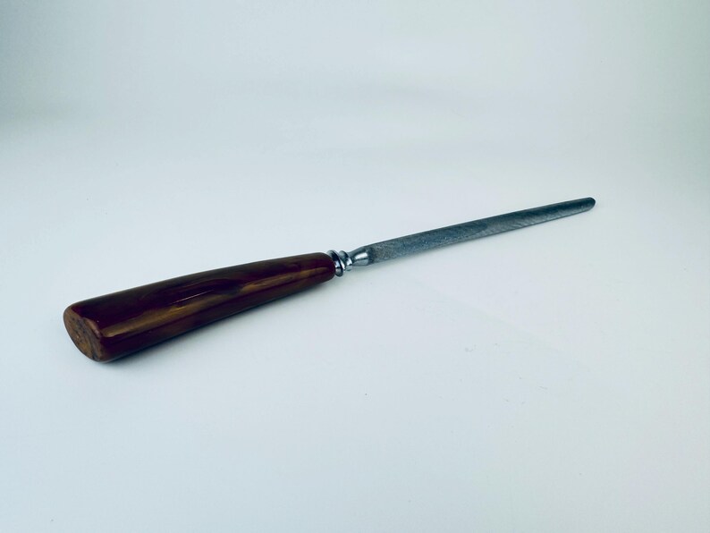 May include: A brown wooden handled steel knife sharpener.