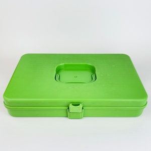 Op de afbeelding: Een felgroene plastic opbergdoos met een sluiting en een ingezonken handvat op de deksel.