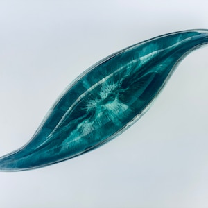May include: A teal and white resin leaf-shaped dish with a swirling pattern. The dish is made of resin and has a glossy finish.