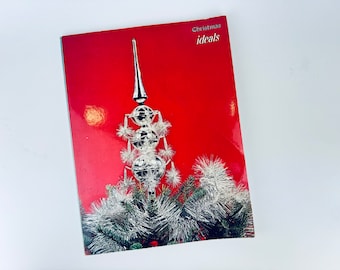 May include: A red book with the title "Christmas ideals" on the cover. The cover features a silver Christmas tree topper with a star on top and a red background.