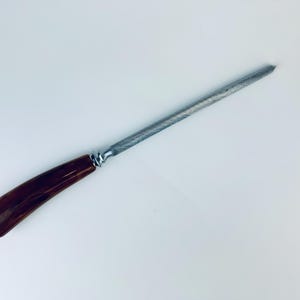 May include: A brown and silver steel knife sharpener with a wooden handle.
