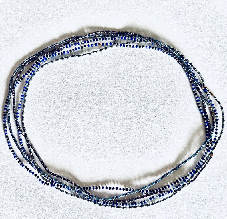 May include: A multi-strand beaded necklace with blue, silver, and clear beads.