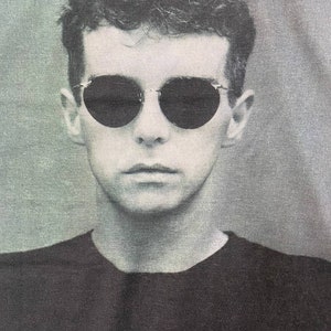 Puede incluir: Una foto en blanco y negro de una persona con gafas de sol y una camisa negra.