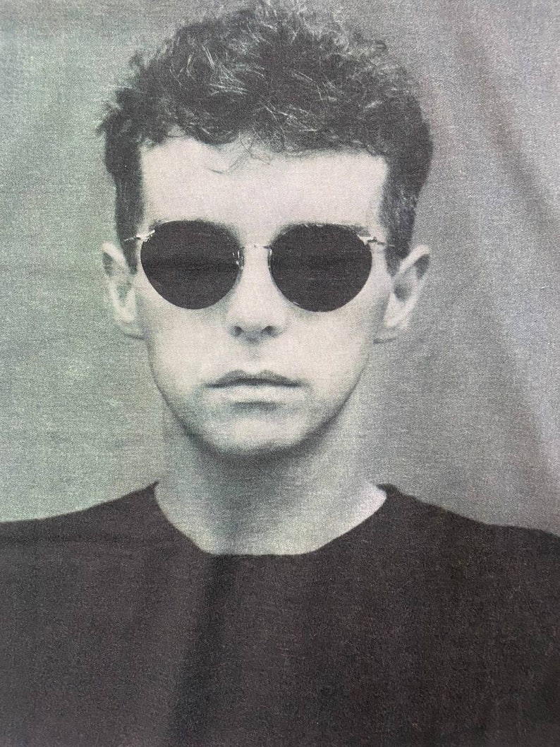 Puede incluir: Una foto en blanco y negro de una persona con gafas de sol y una camisa negra.