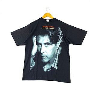 May include: Black t-shirt featuring a photo of Bryan Ferry, with the text "MAMOUA" and "BRYAN FERRY" in red and white.