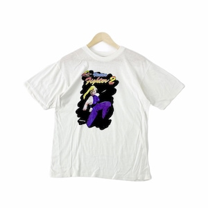 May include: White t-shirt featuring a graphic of a female character from the video game Street Fighter 2. The graphic is in a black and purple colour scheme and includes the text "Street Fighter 2".