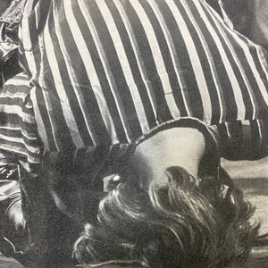 Pu&ograve; includere: Una camicia a righe bianche e nere con la testa e i capelli di una persona visibili sotto.