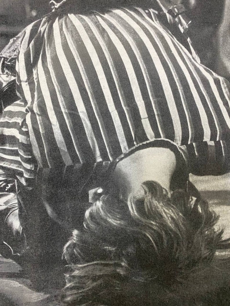 Pu&ograve; includere: Una camicia a righe bianche e nere con la testa e i capelli di una persona visibili sotto.