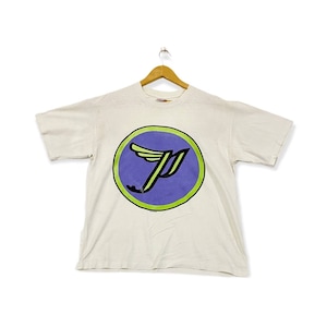 May include: White t-shirt featuring a purple and green logo of a winged letter "P" within a circle.