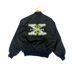 Könnte beinhalten: Schwarze Bomberjacke mit einem grün-weißen gestickten Logo, das auf der Rückseite "Generation X" lautet.