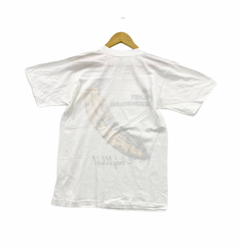 May include: White t-shirt with a faded graphic print of a banana and the text "Andy Warhol" on the back.