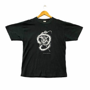 May include: Black t-shirt with a white graphic of a creature with a dragon-like tail. The text "© 1997 Miramax Films" is printed below the graphic.