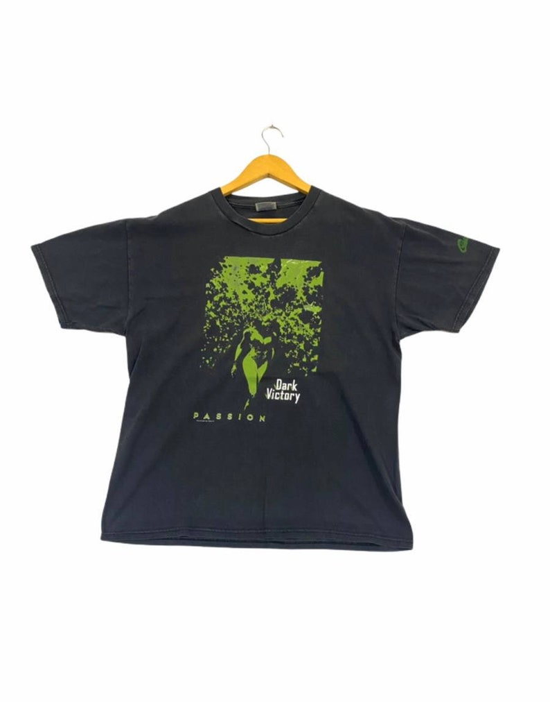 May include: Black t-shirt with a green graphic print of a woman in a forest with the text "Dark Victory" and "Passion" below.