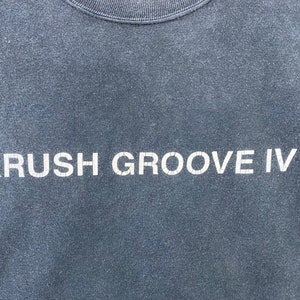 K&ouml;nnte beinhalten: Ein dunkelblaues T-Shirt mit dem Aufdruck "KRUSH GROOVE IV" in wei&szlig;.