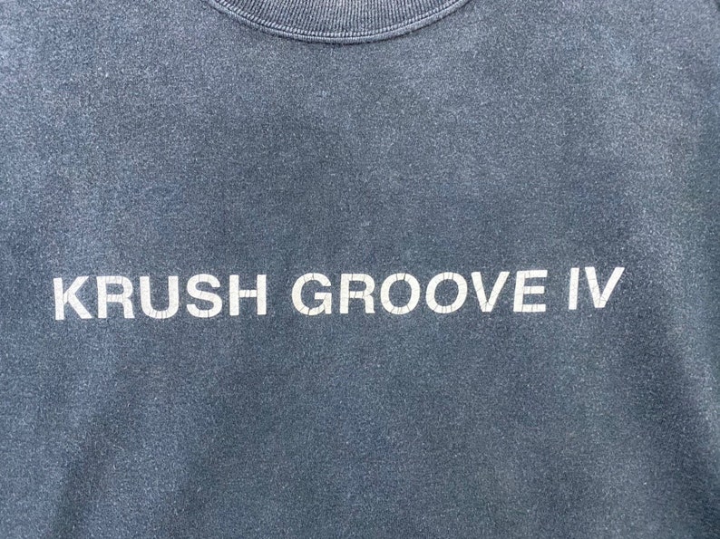 K&ouml;nnte beinhalten: Ein dunkelblaues T-Shirt mit dem Aufdruck "KRUSH GROOVE IV" in wei&szlig;.