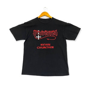 May include: Black t-shirt with a red graphic of a flaming upside-down cross and the text "Possessed Seven Churches".