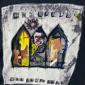 Puede incluir: Camiseta negra con un estampado gr&aacute;fico blanco de una imagen estilizada de tres casas con un sol rojo, una cara y una mano. El texto "The Offspring" y "Smash" est&aacute; impreso en la camiseta.