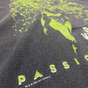 May include: A black t-shirt with a green graphic print of a face and the text "PASSION" in green letters. The text "TM & &copy; 2000 DC COMICS" is printed in white below the graphic.