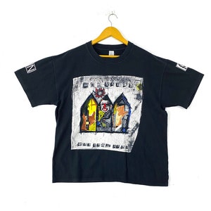 Puede incluir: Camiseta negra con una impresi&oacute;n gr&aacute;fica de la banda "The Offspring" y su &aacute;lbum "Conspiracy of One".