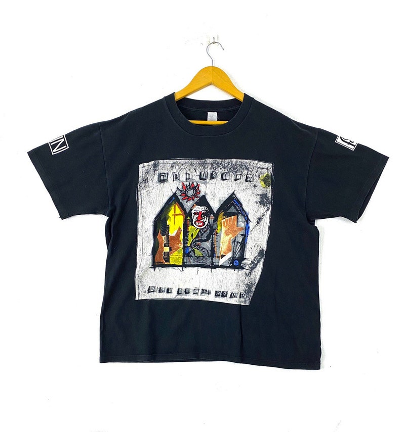 Puede incluir: Camiseta negra con una impresi&oacute;n gr&aacute;fica de la banda "The Offspring" y su &aacute;lbum "Conspiracy of One".