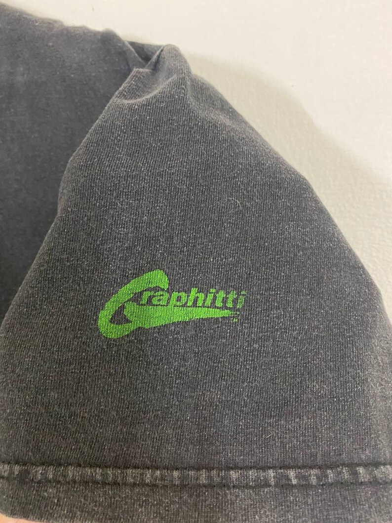 May include: A black t-shirt with a green "Graphiti" logo on the bottom right corner.