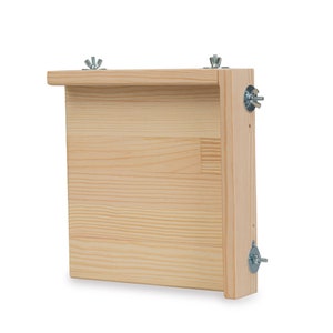 Puede incluir: Un marco de madera con un acabado de madera clara y herrajes metálicos. El marco está fijado a una pared con tornillos.