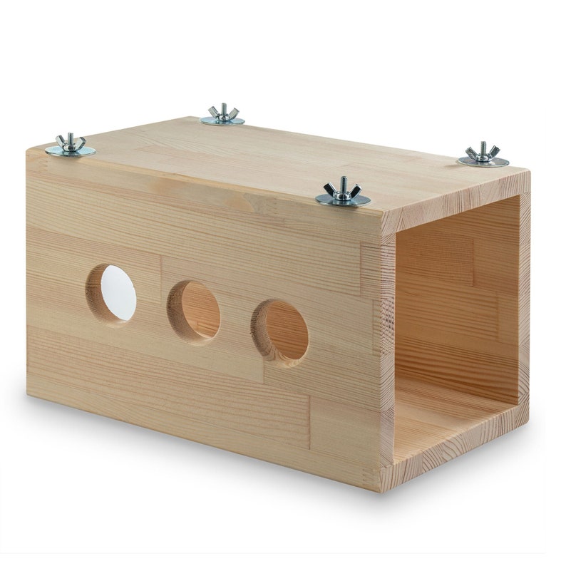 May include: A light wood rectangular box with three round holes cut out of the front. The box has four metal screws on the top.