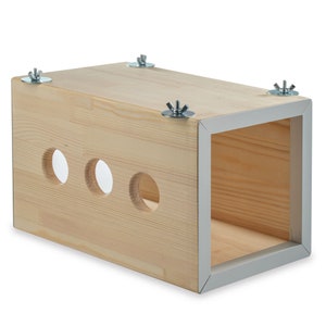 May include: A wooden box with three holes and a grey trim. The box is held together with four silver screws.