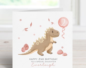 May include: A pink and brown dinosaur birthday card with a pink balloon that says "2" and the text "Happy 2nd Birthday to a special daughter Everleigh".
