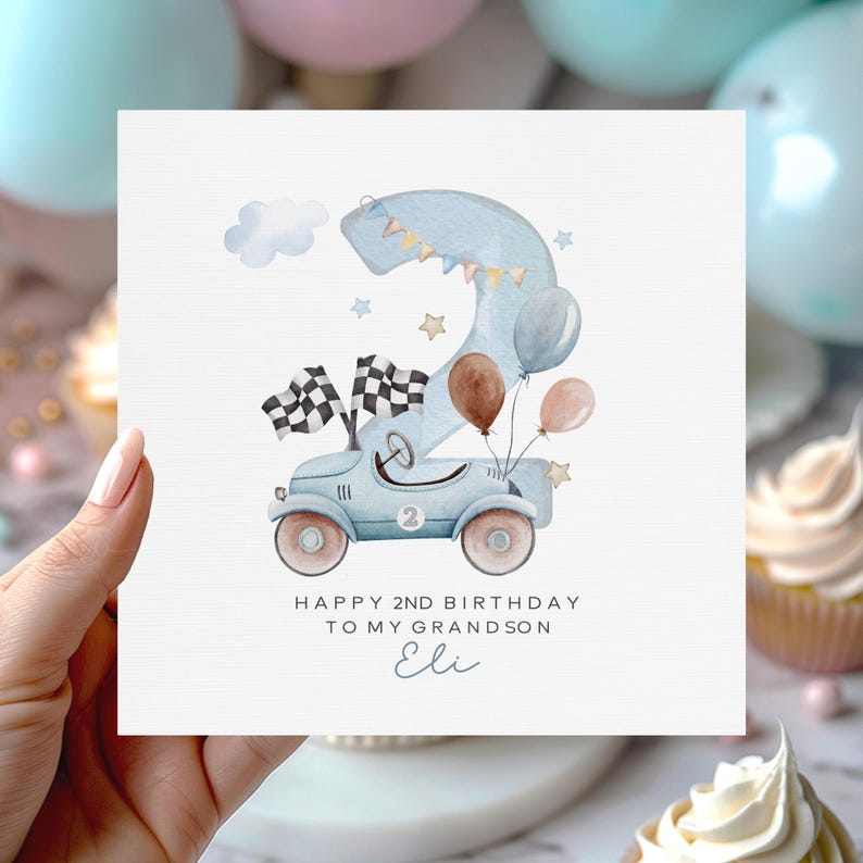 Puede incluir: Tarjeta de cumplea&ntilde;os acuarela con un coche de carreras azul claro, banderas a cuadros y globos. El n&uacute;mero 2 tiene forma de dinosaurio. La tarjeta dice: "Feliz 2&ordm; cumplea&ntilde;os a mi nieto Eli".