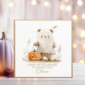 May include: A card with a cute illustration of a bear dressed as a ghost holding a jack-o-lantern. The card says "Happy 1st Halloween to a special niece Olivia".