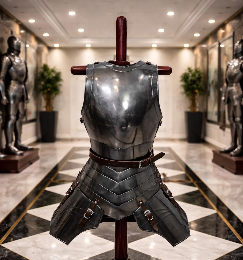 May include: A polished steel breastplate and skirt armor, displayed on a wooden stand. The armor features a brown leather belt and straps with buckles. The background shows a hallway with two full suits of armor and decorative plants.