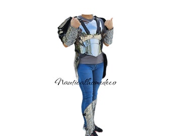 Könnte beinhalten: Ein silberner Metallbrustpanzer mit passender Arm- und Beinschützer. Die Rüstung wird über einer blauen Jeans getragen.