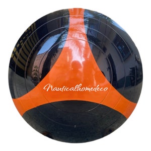 Puede incluir: Una boya náutica negra y naranja con el texto "Nauticalhomedeco" impreso en la parte delantera.