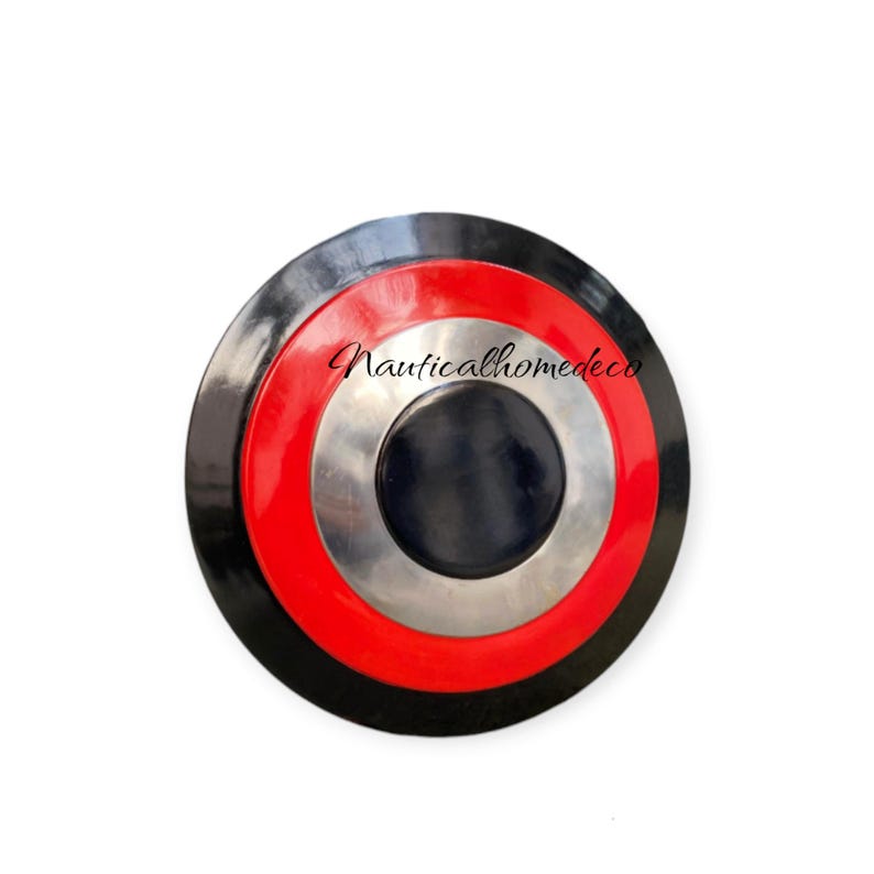K&ouml;nnte beinhalten: Ein schwarzer, roter und silberner runder Schild mit konzentrischem Kreisdesign. Der Schild hat einen schwarzen Au&szlig;enring, einen roten Ring, einen silbernen Ring und einen schwarzen Mittelkreis.