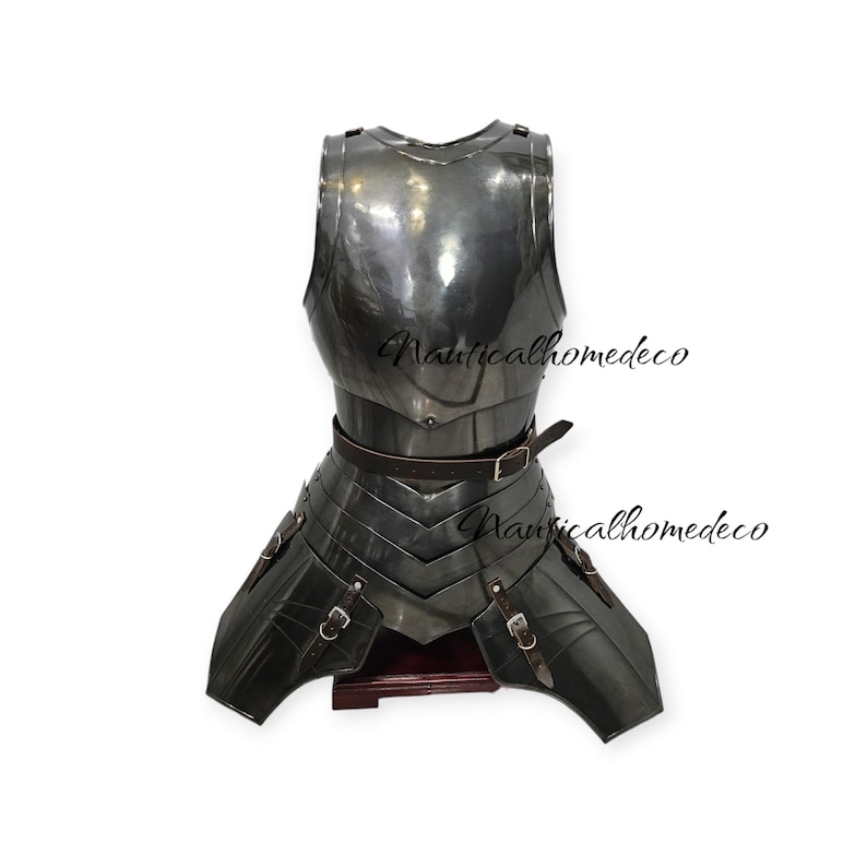 May include: A dark metal breastplate and tassets with a brown leather belt and straps. The armor has a polished finish and is displayed on a wooden stand. The text "Nauticalhomedeco" is visible on the armor.