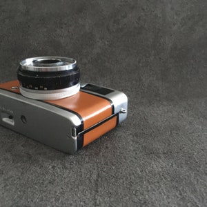 Contrail Film Camera - Angled right-side view of caramel brown leather Olympus Trip 35, vintage 35mm camera