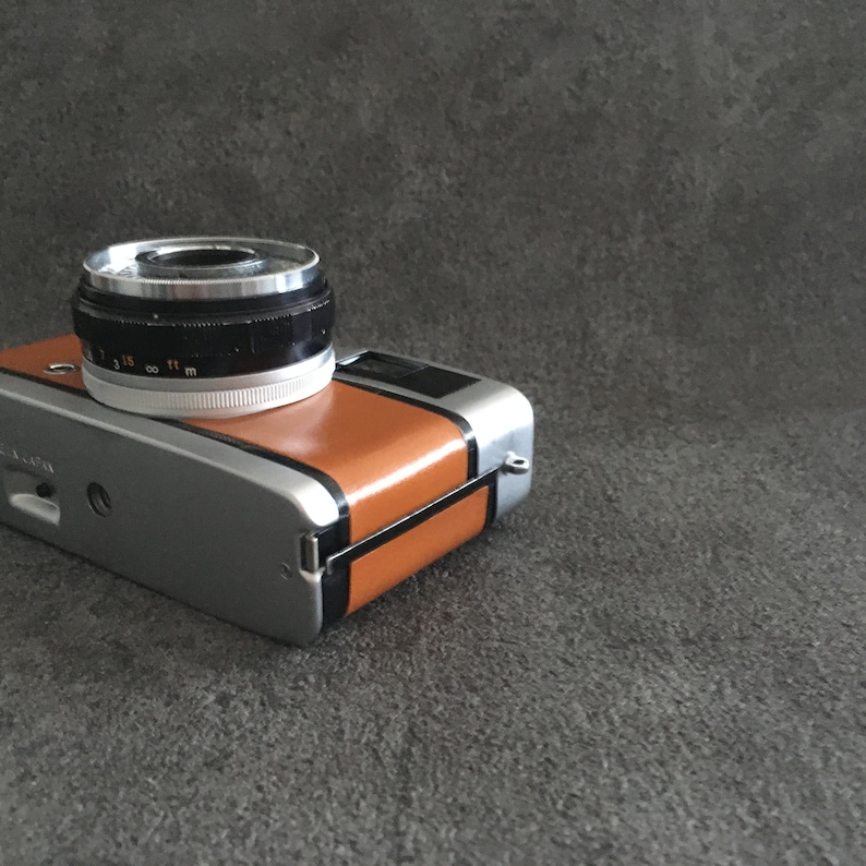 Contrail Film Camera - Angled right-side view of caramel brown leather Olympus Trip 35, vintage 35mm camera