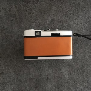 Contrail Film Camera - Back view of Olympus Trip 35 camera with caramel brown leather, showing controls and texture