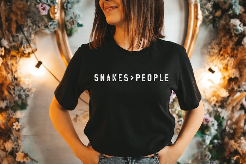 May include: A black t-shirt with the text "SNAKES>PEOPLE" printed in white on the front.