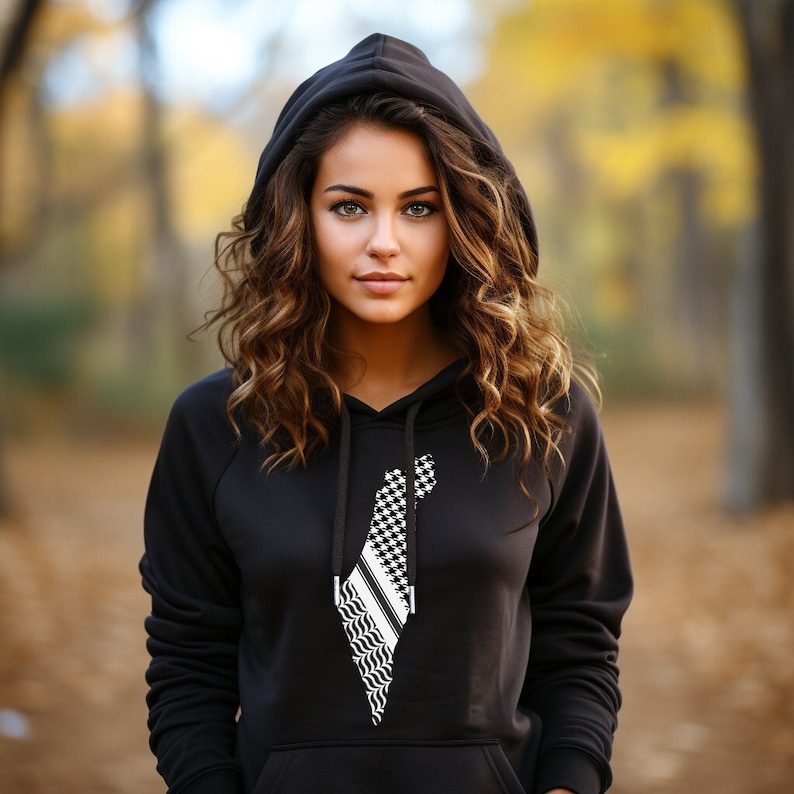 May include: A black hooded sweatshirt with a white graphic of a stylized map of Israel. The graphic is made up of a black and white pattern.