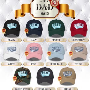 May include: A selection of "Dad Hats" in a variety of colours, each displaying "North Carolina" in a curved, white font. Colours include black, navy, spruce, cranberry, white, pink, light blue, stone, green camo, dark grey, and khaki.