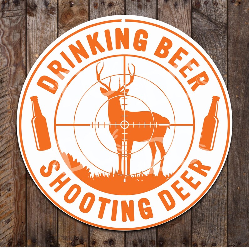 May include: White round sign with orange text and a deer silhouette in the center. The text reads "Drinking Beer Shooting Deer".