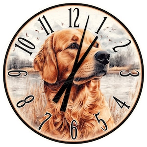 Könnte beinhalten: Eine runde Uhr mit einer Illustration eines Golden Retriever Hundes. Das Zifferblatt der Uhr hat römische Ziffern und schwarze Zeiger. Der Hund schaut nach rechts und ist vor dem Hintergrund eines Sees und Schilfs platziert.