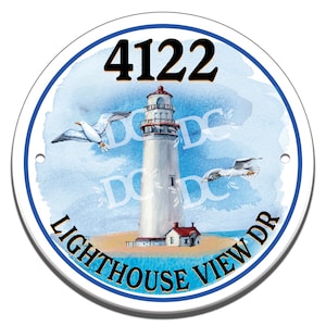 Puede incluir: Un letrero redondo blanco con un borde azul. El letrero presenta una ilustración de acuarela de un faro con gaviotas volando por encima. El texto "LIGHTHOUSE VIEW DR" está escrito en un arco azul debajo del faro. El número "4122" está impreso en negro en la parte superior del letrero.