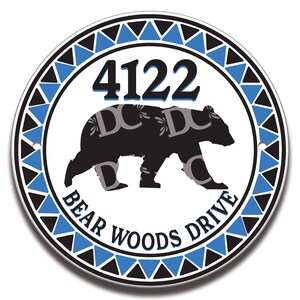 May include: A round, white sign with a black bear silhouette and blue and black triangular border. The sign reads "4122 Bear Woods Drive".